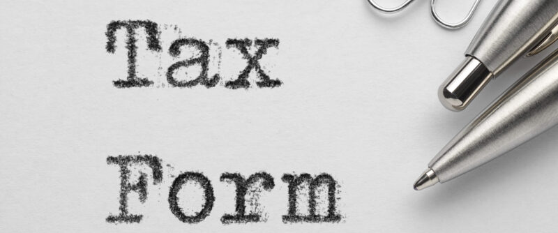 Tax form words printed with typewriter, pen and paper clips